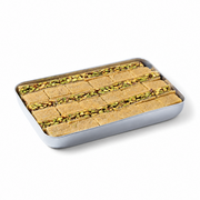 A rectangular metal tray holding several cut pieces of baklava or pastry, arranged in rows and topped with a green pistachio-like filling, photographed on a clean white background.